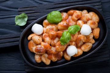 Frying pan with gnocchi alla Sorrentina, black wooden surface