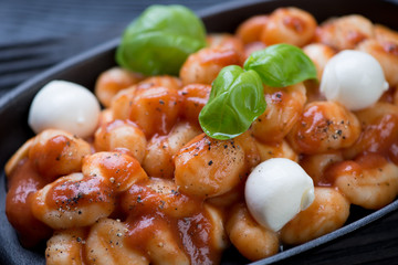 Closeup of potato gnocchi with tomato sauce and mozzarella balls