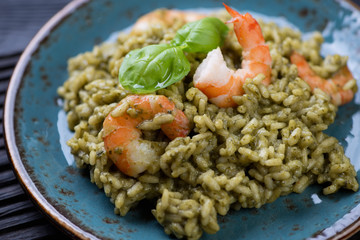 Closeup of spinach risotto with tiger shrimps, selective focus