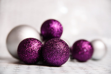 Purple Sparkling and Silver Christmas balls Close-up on a soft focus light background. horizontally holiday banner