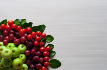 photo green apple, grape and cherry tomatoes, all fresh on a white wooden board