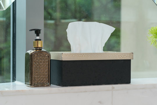A tissue(Kleenex, toilet paper) with leather case, curtain on the marble desk
