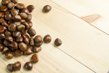 Chestnuts on pine wood background.