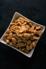 Top view on bowl full of salted peanuts