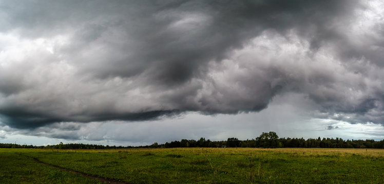 Scenic view of field against storm clouds