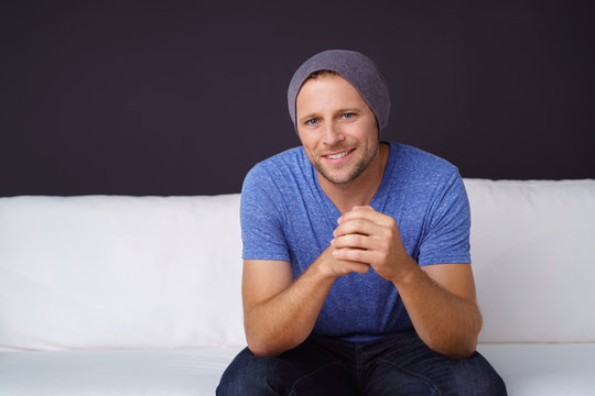 lächelnder mann sitzt auf einem weißen sofa