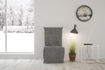 White room with chair and winter landscape in window. Scandinavian interior design