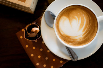 Coffee cup and coffee beans on a dish with a spoon. top view on the wooden table