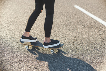 sunrise skateboarding woman legs on the board