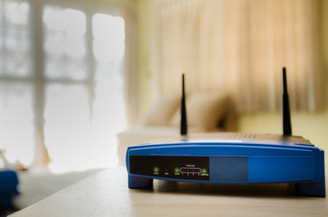closeup of a wireless router on living room at home with a window in the background