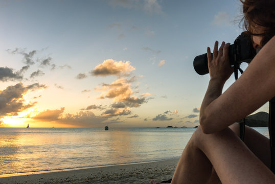 Bikini woman photographer taking picture of tropical beach sunset