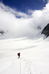 Naklejka na ściany i meble Alpinist traversing Mensu Glacier in Altai Mountains, Russian Federation