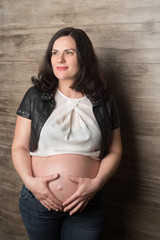 Pregnant woman in jeans at the wall