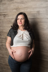 Pregnant girl in jeans and a leather jacket