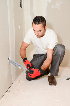 construction industry electrician with tools renovating electrical network in a house construction site