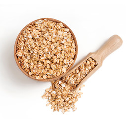 Scoop and oat flakes in wooden bowl on white background. Healthy food. Top view, copy space, high resolution product