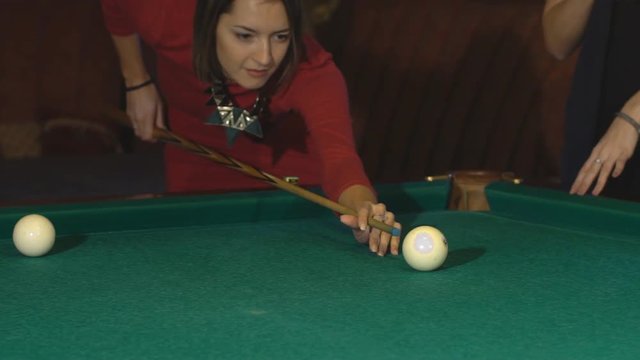 beautiful woman in red evening dress playing pool