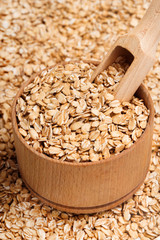 Close up oats in wooden bowl and scoop. Healthy food. Top view, high resolution product.