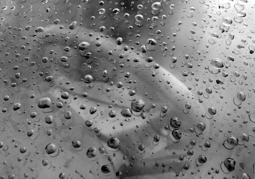 Rain drops on frot car window in black and white.