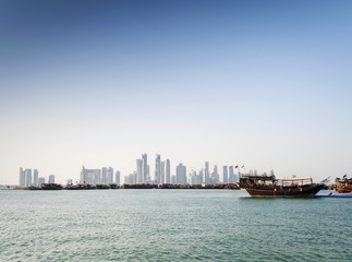 doha city urban skyline view and dhow boat in qatar