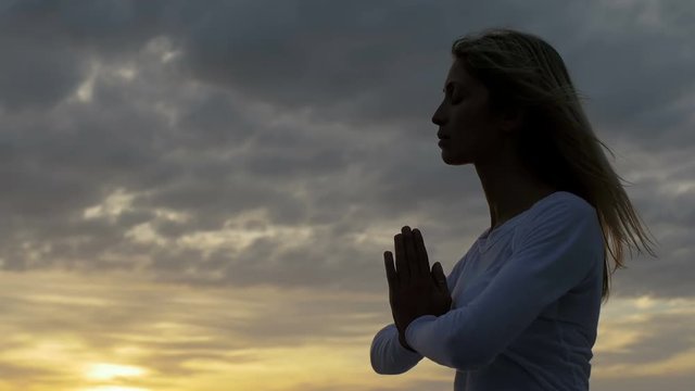 woman deep in meditation at the sunset: yoga, spiritual, religion