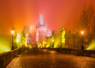 Charles Bridge and the towers of the old city of Prague on fog, Czech Republic