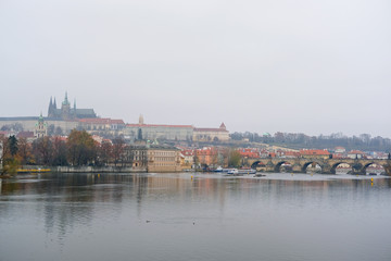 Naklejka na ściany i meble Prague, Czechia - November, 24, 2016: Panorama of an old Prague, bridges and embankment of Vitava river, Czechia