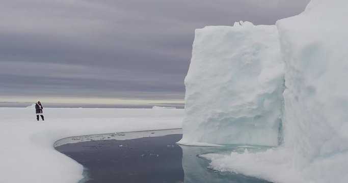 Photographer inspects iceberg in Baffin Island