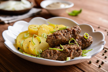 Cevapcici made of minced meat with potato, leek and onion