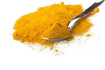 dust of ground turmeric on the spoon