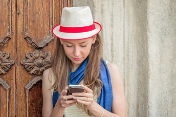 woman with cellphone standing outdoors checking messages