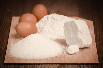 Simple baking tools and ingredients on a wooden table and white background. Concept from alfaphotorus