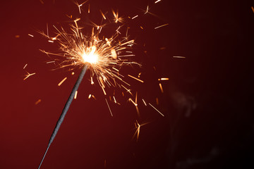 Christmas sparkler on red background