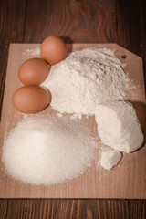 Simple baking tools and ingredients on a wooden table and white background. Concept from alfaphotorus