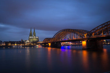 Obraz premium Cologne Cathedral and Hohenzollern Bridge at sunset / nighttime