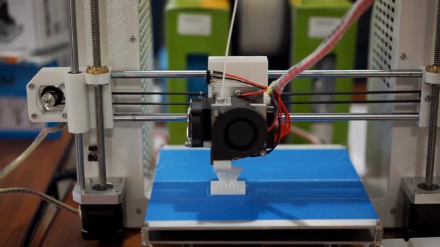 3D printer printing a figurine, additive manufacturing in progress, workshop