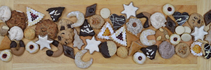 ribbon out of different kinds of Christmas cookies on a breadboard 