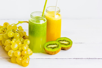 Fresh detox juices in glass bottles on white background