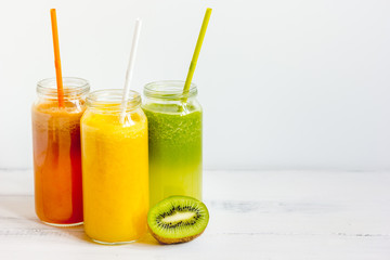 Fresh detox juices in glass bottles on white background