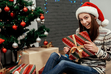 happy woman holding surprised christmas present box. girl in swe