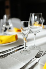 beautiful empty wine glasses and yellow napkin on a decorated table close-up.