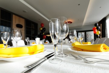 beautiful empty wine glasses and yellow napkin on a decorated table close-up.