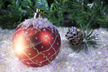 New Year's ball on a background of snow and a fir tree branch