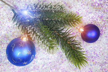 Branch of a firtree and New Year's ball on a background of decorative snow..