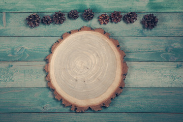 Round boardRound board with pine cones on old wooden background. Top wiev