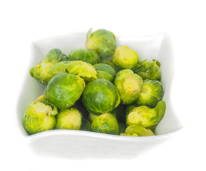 White designer bowl with fresh green brussels sprouts isolated on