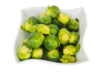 White designer bowl with fresh green brussels sprouts isolated on