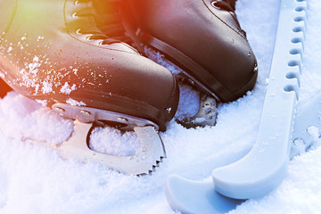 black figure skates lying in the snow and bright sun