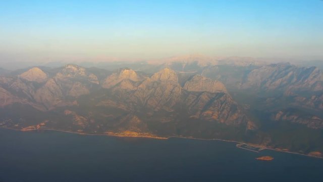 Breathtaking view of towering mountains and high rocks from airplane, flight