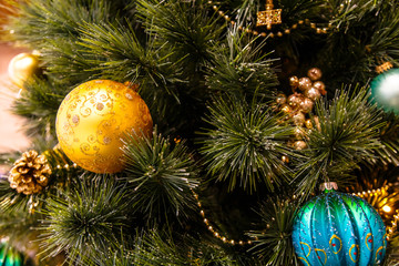 Golden balls hanging on Christmas tree.